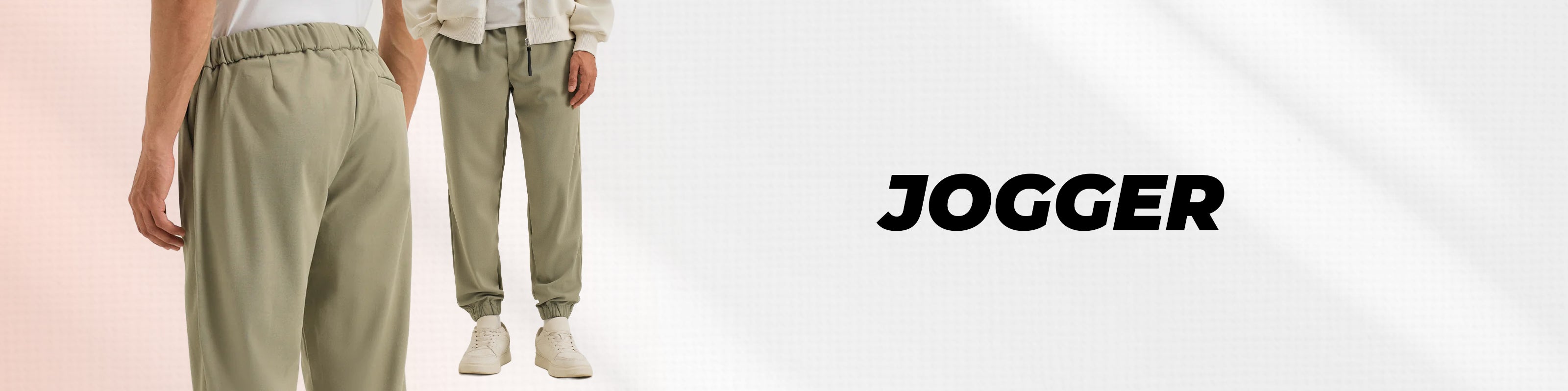 A pair of jogger pants in a light sage green color, shown on a model from the back and front against a clean white background with the word 'JOGGER' printed on the right.