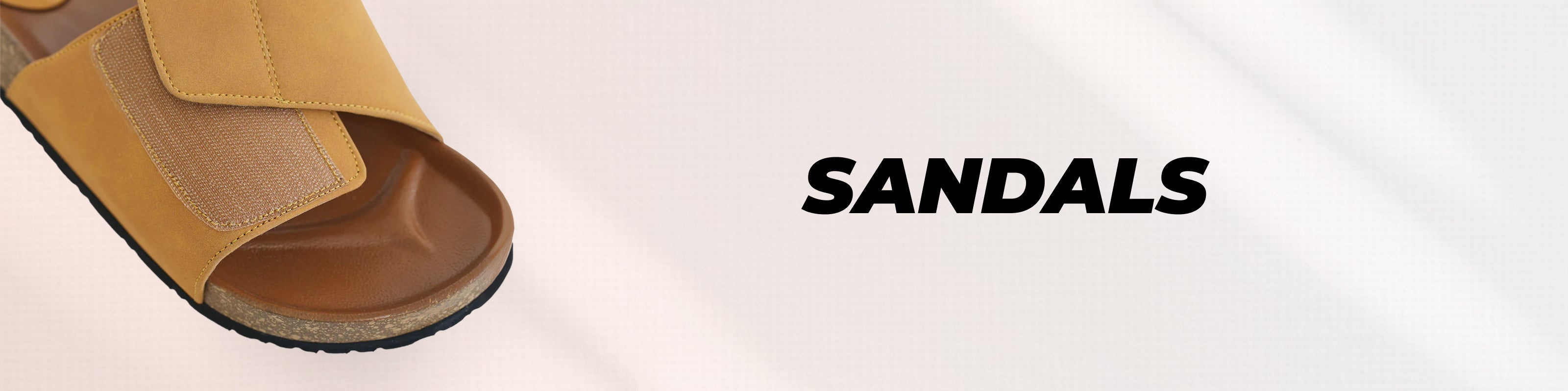 A tan slide sandal is partially visible on the left side of a light beige background, with the word 'SANDALS' printed in bold black text on the right.